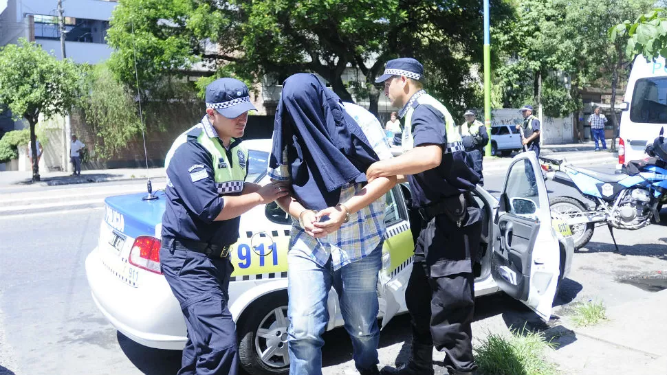 EN TRIBUNALES. Uno de los sospechosos es escoltado por colegas, tras haber sido trasladado en un patrullero del 911 para que preste declaración indagatoria.  LA GACETA / FOTO DE ANALÍA JARAMILLO