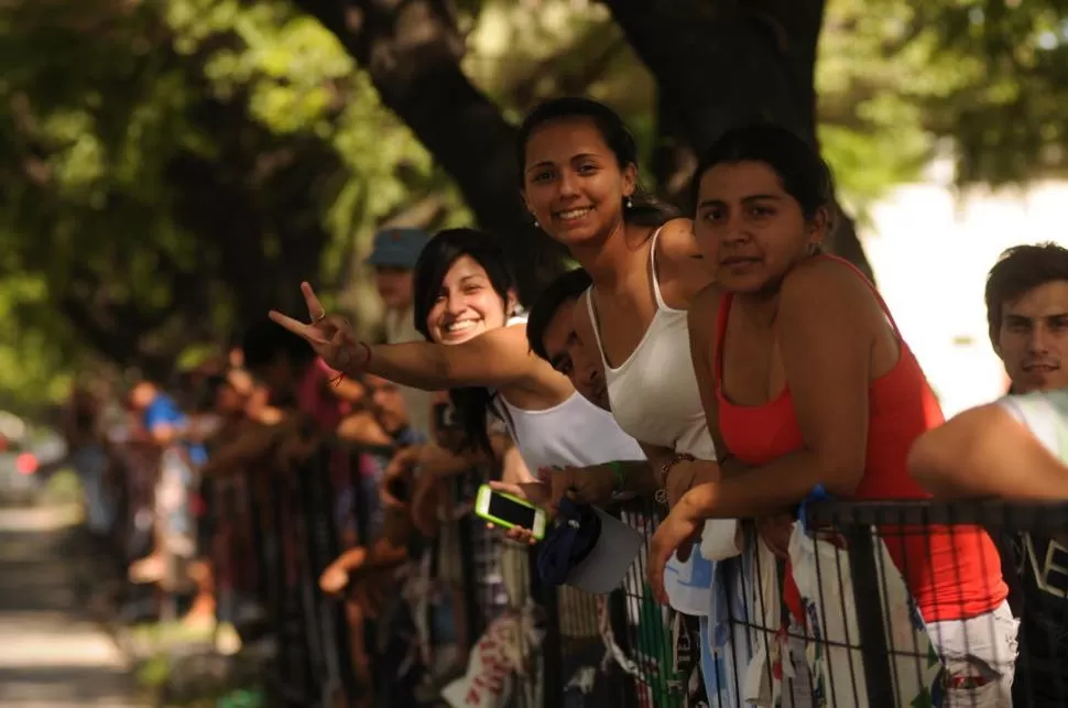 ENTUSIASMO TRAS LAS VALLAS. Mientras sus novios se fijan en aburridos detalles técnicos, ellas dominan nombres y aspecto físico de los corredores. 