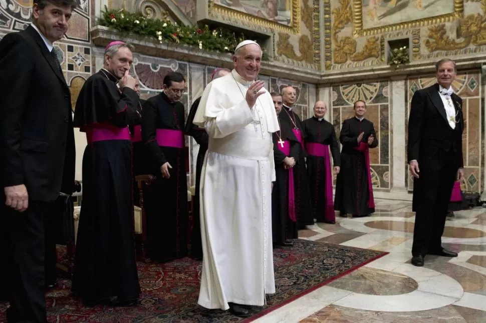 DESPEDIDA. Flanqueado por algunos cardenales, Francisco se retira de la audiencia con los diplomáticos. REUTERS