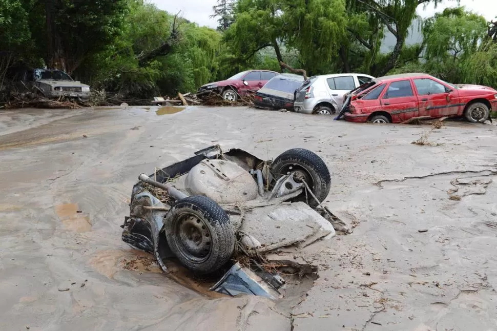 ENTERRADOS EN EL LODO. Autos y camionetas fueron tumbados por la fuerza del alud, que los dejó sepultados en el barro y abollados por las piedras. dyn