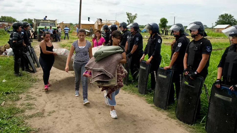 ABANDONAN LOS TERRENOS. Los usurpadores retiraban sus pertenencias ante la mirada de 200 policías. LA GACETA / FOTO DE JORGE OLMOS SGROSSO