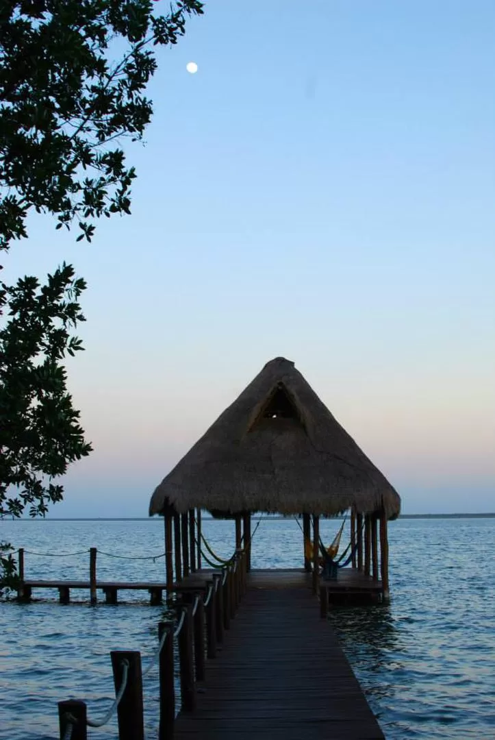 MAGNIFICENCIA. Atardece en la Laguna de Bacalar mientras en la calma aparece la Luna.  gentileza  anabella maudet