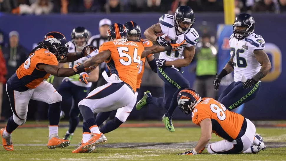 EN CARRERA. Harvin salta la marca de los Broncos para comenzar una carrera que solo detendrá después de anotar. REUTERS