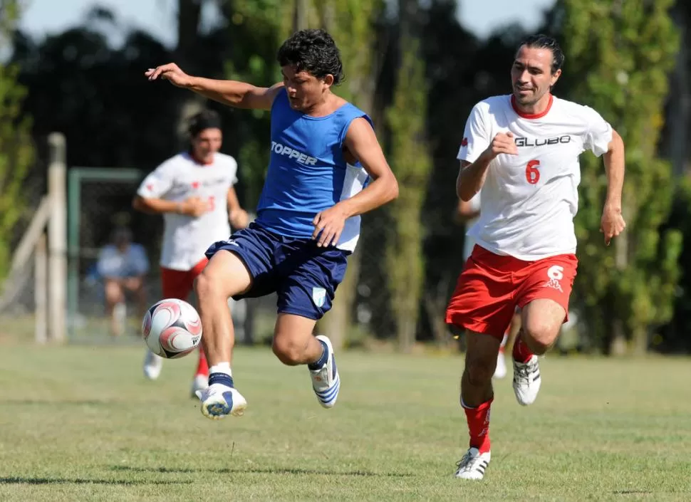 ILUSIÓN. “Pulguita” controla la bola ante Domínguez, de Huracán, en 2009.