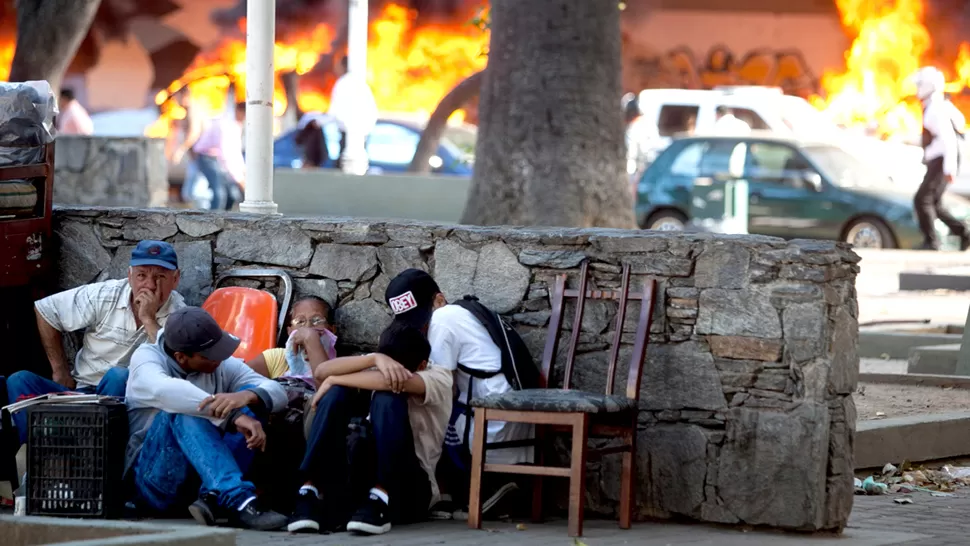 DRAMÁTICO. Trabajadores se resguardan de los disparos. FOTO TOMADA DE INFOBAE.COM