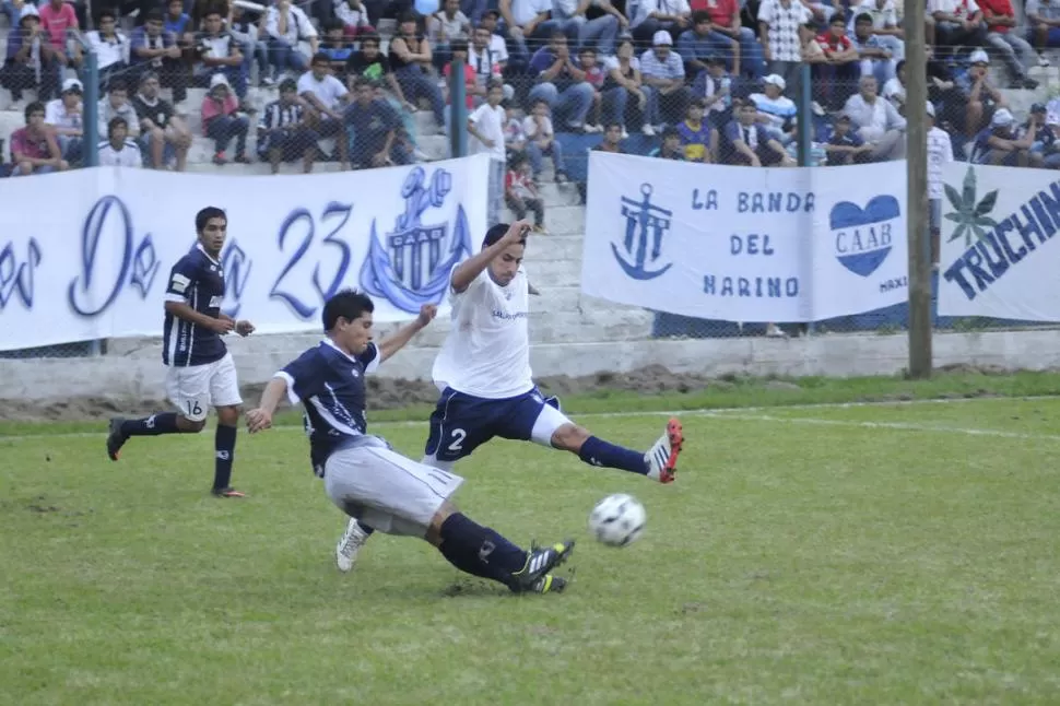 A TODO O NADA. Juan Gómez (2), de Almirante Brown, trata de frenar un ataque de Andrés Padilla, de San Juan. 