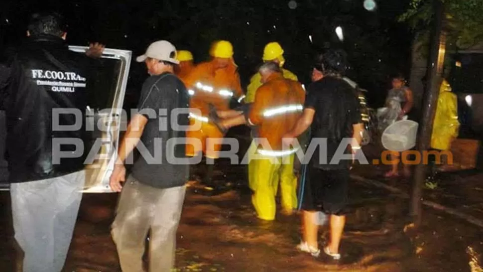 TAREAS. Rescatistas ayudan a familias de Quimilí a evacuar sus casas. FOTO DE DIARIOPANORAMA.COM