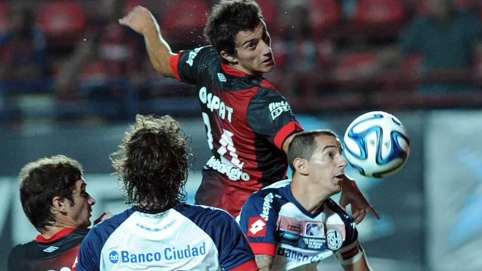 PELEADO. Martín Luque y el Pipi Romagnoli disputan una pelota parada en el área de Colón. TELAM