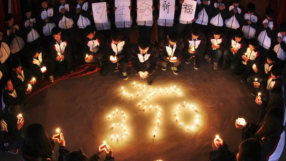 HOMENAJE. Familiares de los pasajeros fallecidos rezan luego de conocerse la noticia. REUTERS. 