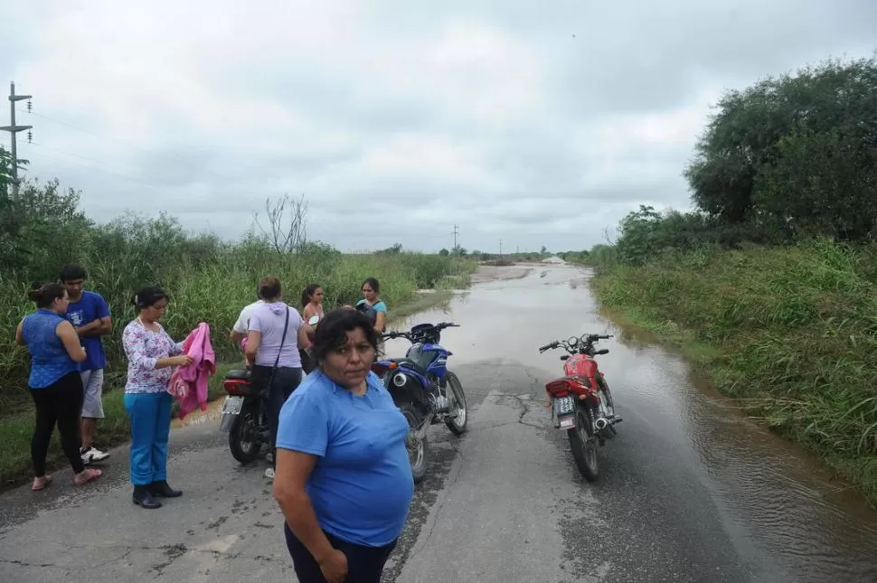 ANGUSTIADA. Eva Cárdenas espera que el agua baje para poder volver a su casa en moto; en Puesto Los Pérez la espera su marido. la gaceta / fotos de osvaldo ripoll 