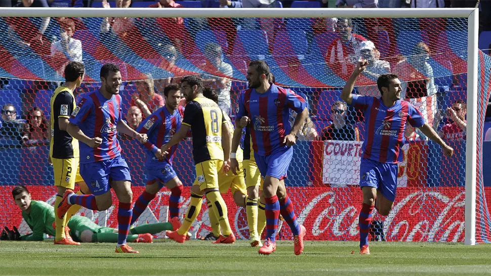 CONTRACARA. El festejo de los jugadores de Levante contrasta con la decepción de los colchoneros. REUTERS