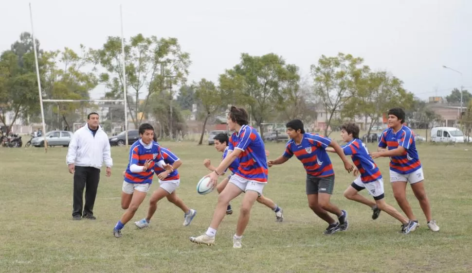 ZORROS DE MAÑAS Y PELOS NUEVOS. José Lescano fiscaliza los ejercicios con pelota en la cancha principal del club de Aguilares. El objetivo es llegar al final del torneo “lo más enteros posible”. 