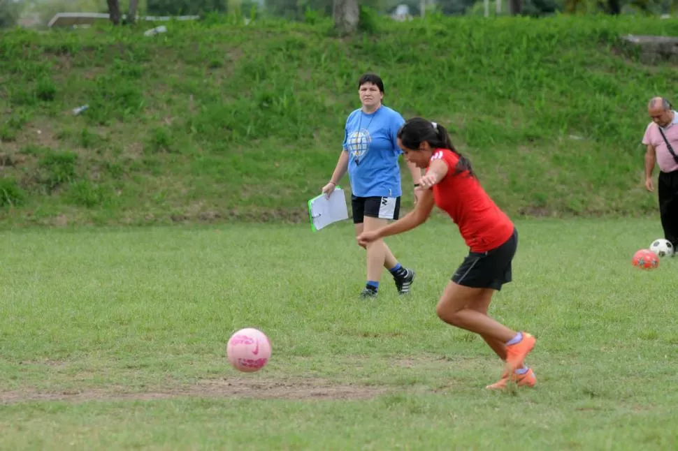 ATENTA A CADA MOVIMIENTO. Carpeta en mano, Claudia Lencina observa a su jugadora a punto de impactar la pelota. 