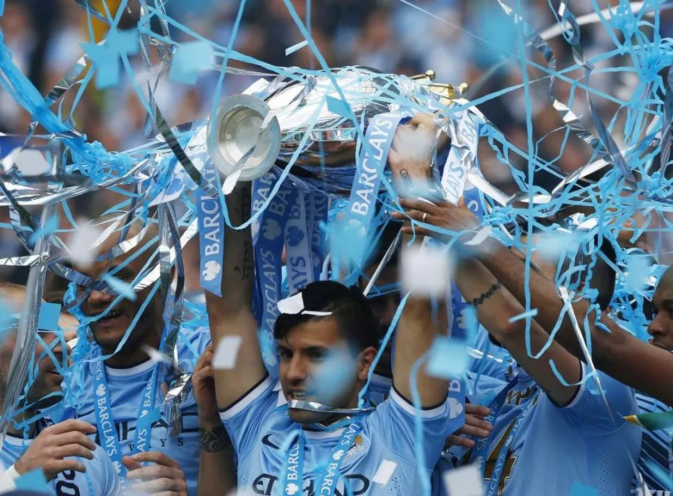 MANOS Y TROFEO, ARRIBA. Agüero levanta la Copa de la Liga Premier en medio de una lluvia de serpentinas y papelitos. 