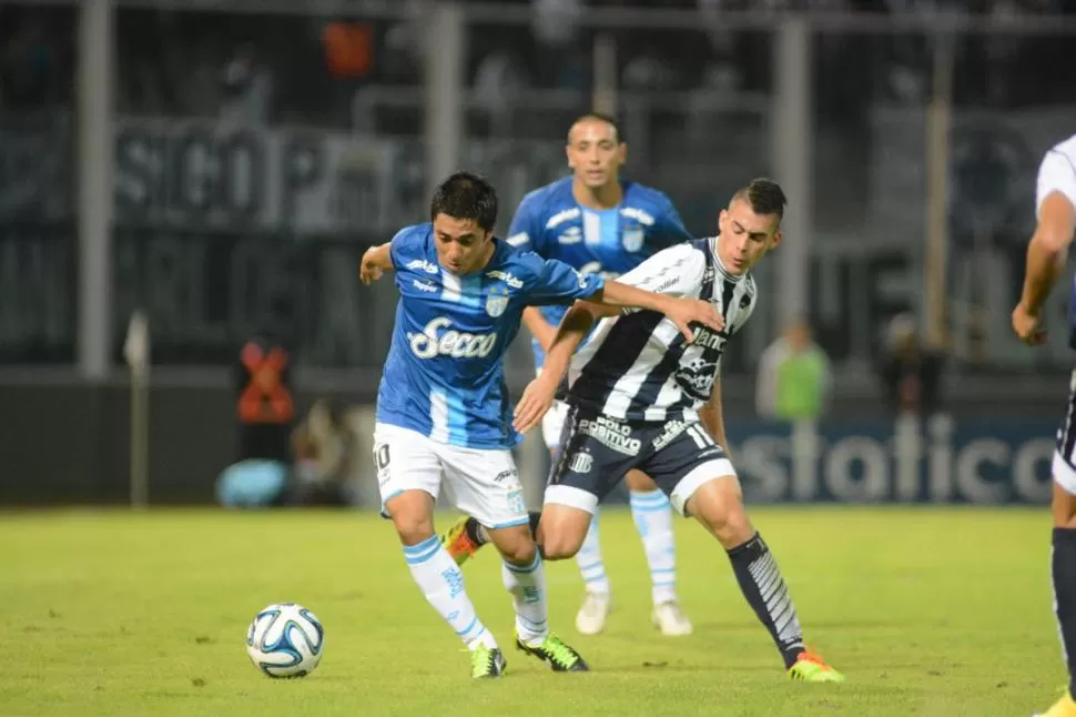 CARRERA. Alfredo Carrizo, que anoche no destelló y el equipo lo sintió, se adelanta en la marca de Cristian Pavón, de la “T”. 