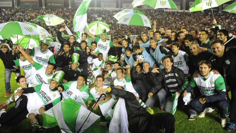 PURA FIESTA. Los jugadores y un grupo de hinchas de Banfield celebran el retorno a la primera división. TELAM