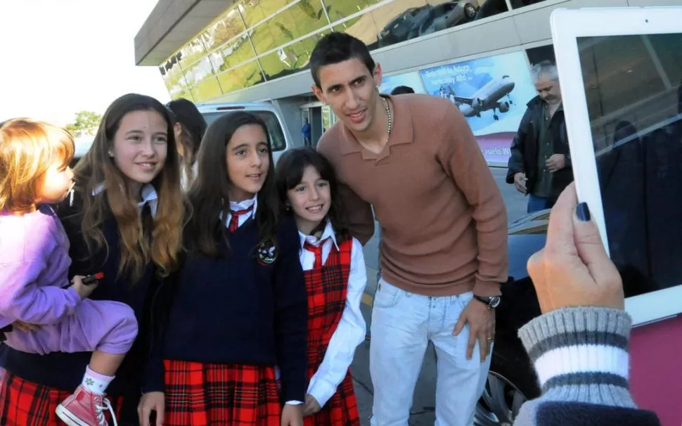 CON SU ÍDOLO. Recién salidas del colegio, unas pequeñas rosarinas se sacan una foto con Di María a la llegada del volante de Real Madrid al aeropuerto Fisherton. “Fideo” recién se acoplará al grupo en Ezeiza, el viernes. 