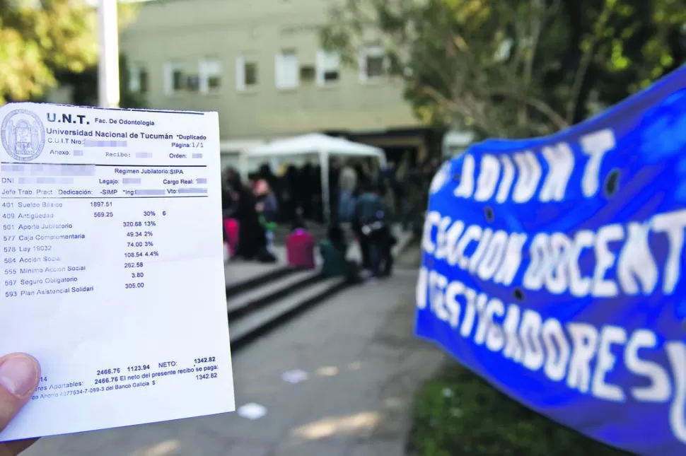 PRUEBA. Un Jefe de Trabajos Prácticos, de dedicación simple, muestra su boleta durante la protesta en el centro Prebisch: $ 1.342,82 de bolsillo. LA GACETA / FOTO DE JORGE OLMOS SGROSSO