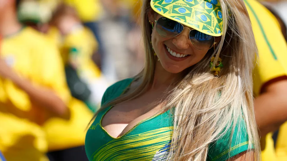 BELLEZA EN LAS TRIBUNAS. Las garotas se ganaron las miradas y los flashes en el estadio Arena Corinthians. REUTERS