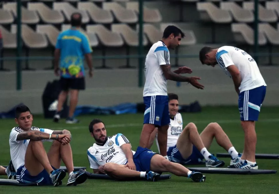 RELAJADO. Arriba, Rojo descansa durante el entrenamiento de ayer en Belo Horizonte. A la izquierda, ejecutando su ahora famosa rabona.  DYN