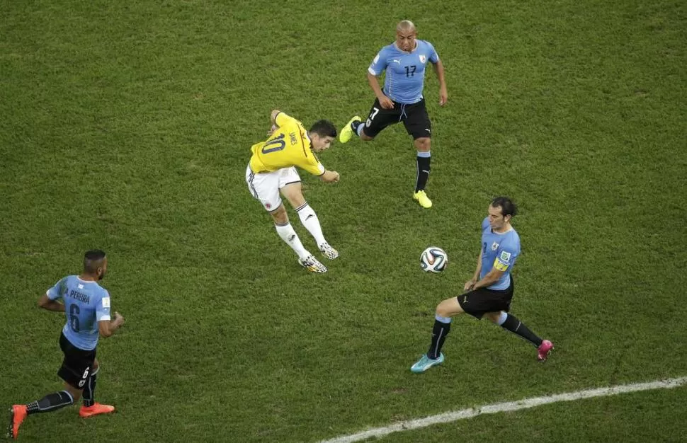 EXQUISITEZ. Sin dejarla picar, Rodríguez remata y marca el primer gol ante la mirada de Arévalo Ríos y el intento de bloqueo de Godín, el héroe ante Italia el martes.  