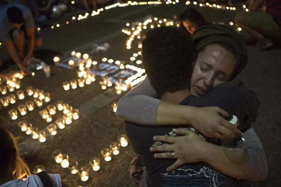 MANIFESTACIONES. En la Plaza de Rabín, en Tel Aviv, una multitud apoyó a los padres de los jóvenes. También mujeres acongojadas encendieron velas  reuters