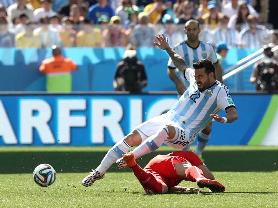 ÁSPERO. Lavezzi entrega la pelota a un compañero justo antes de recibir una dura entrada de un jugador suizo, durante el primer tiempo del partido de ayer.  