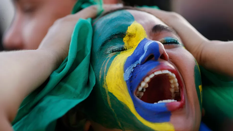 LLANTO Y SILENCIO. Los hinchas brasileños no podían creer que su selección recibió cinco goles en apenas 30 minutos. REUTERS