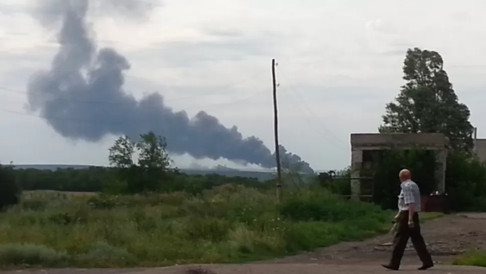 TRAGEDIA EN UCRANIA. Un ciudadano mira sorprendido la columna de humo. 