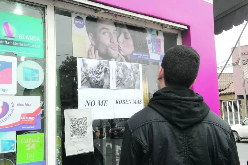 LOS CARTELES. Los transeúntes se detienen a ver las imágenes del robo. la gaceta / fotos de  hector peralta