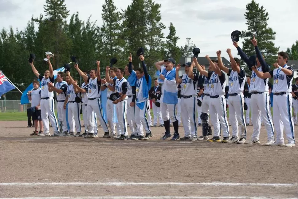 ¡LO HICIERON OTRA VEZ! Nicolás Isa (con gorra y envuelto con la bandera de Argentina), celebra eufórico junto a sus compañeros la obtención del título. Argentina realizó una gran campaña en tierras canadienses. 