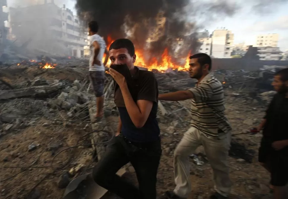 LA DESOLACIÓN. Jóvenes palestinos buscan sobrevivientes del bombardeo sobre el centro de refugiado de Beit Hanoun, en la ciudad de Gaza. reuters