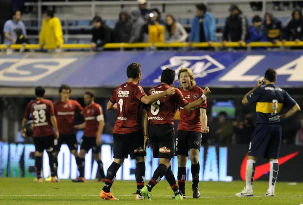 LAS DOS CARAS DEL RESULTADO. Los jugadores de Newell´s se juntan para festejar la victoria. La imagen de Gigliotti -de espaldas- fue la de todo Boca, que entregó poco y se fue envuelto en preocupaciones. 