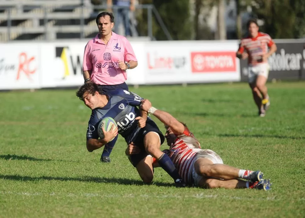 TACKLEADO. El centro de Universitario, Javier Rojas, intenta escaparse del tackle de un jugador del Santiago Lawn Tennis. la gaceta / foto de osvaldo ripoll