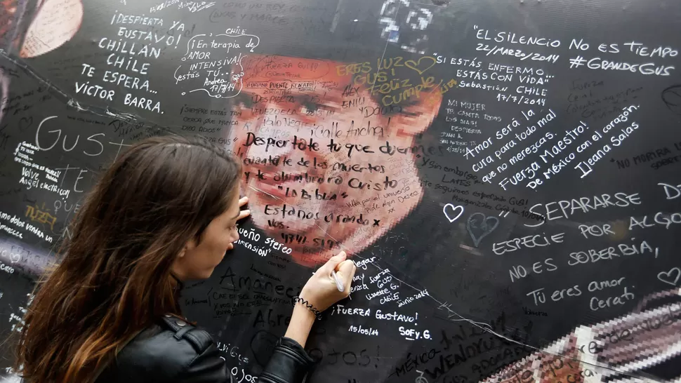 ADORABLE PUENTE. Cientos de fans se acercaron a la clínica Alcla, donde estuvo internado Cerati hasta su muerte. REUTERS