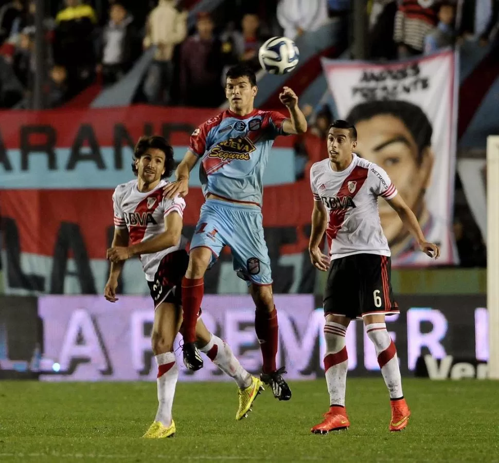 DUELO EN LAS ALTURAS. El tucumano Emilio Zelaya se anticipa a Leonardo Ponzio (izquierda) y a Funes Mori (derecha). 