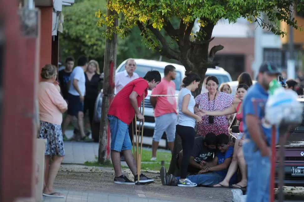 DIFÍCIL MOMENTO. Los familiares y amigos de Daniel Galván se abrazan en la vereda del pasaje Payró al 4.600, minutos después de que lo acribillaran. la gaceta / foto de diego aráoz