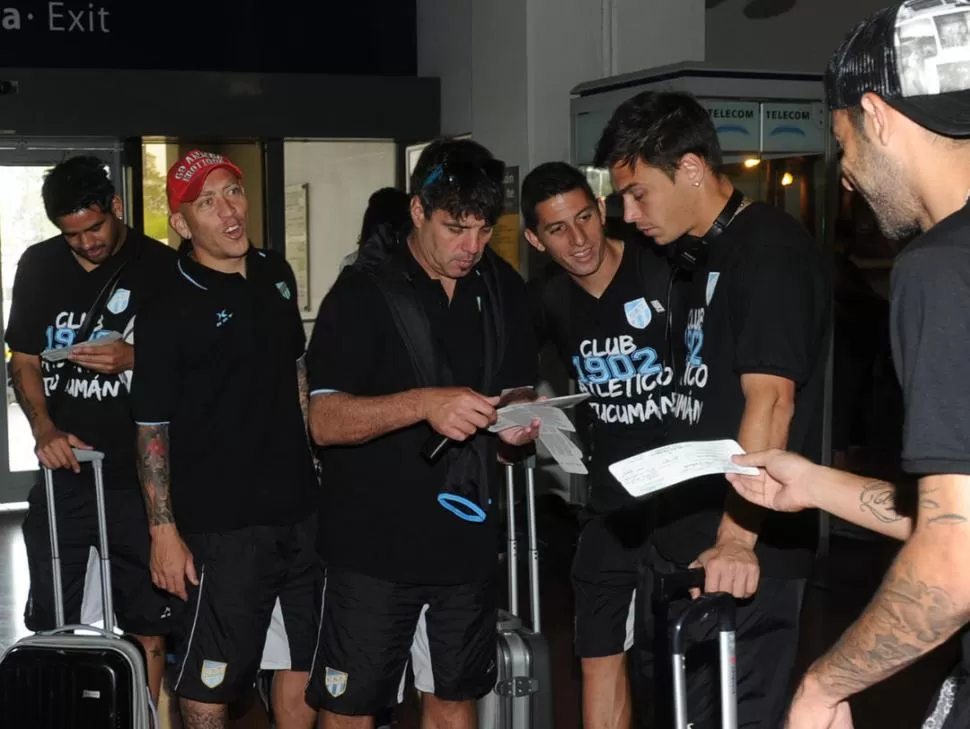 CHECK IN LISTO. El “Profe” Fernández reparte los pases a bordo en el aeropuerto Benjamín Matienzo a Garnier (gorra), García, Calviño y Grahl, minutos antes de subir al avión que los depositará en Buenos Aires 