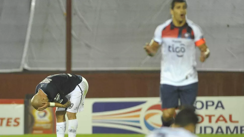 CONTRACARA. Mientras los jugadores de Lanús sufren la eliminación, los paraguayos celebran el pasaporte a la fase siguiente de la Copa Sudamericana. TELAM