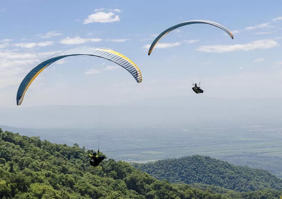 EN EL COMIENZO. Los parapentes despegan desde Loma Bola en los segundos iniciales del vuelo que los llevaría lejos, pero no lo suficiente como para llegar a la meta. 