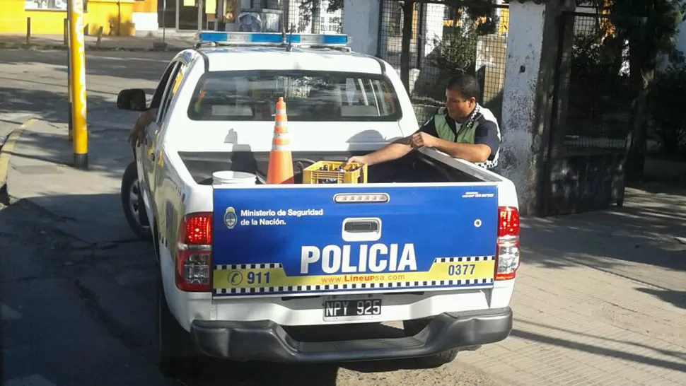 Los fotografiaron con un cajón de cervezas en el patrullero