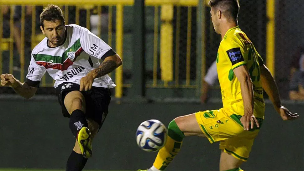 GOLEADOR. Lucas Pratto remata para vencer la resistencia de Fernando Pellegrino,el arquero de Defensa y Justicia y convertir el primero de sus dos goles con el que Vélez venció 2-0 en Florencio Varela. TELAM