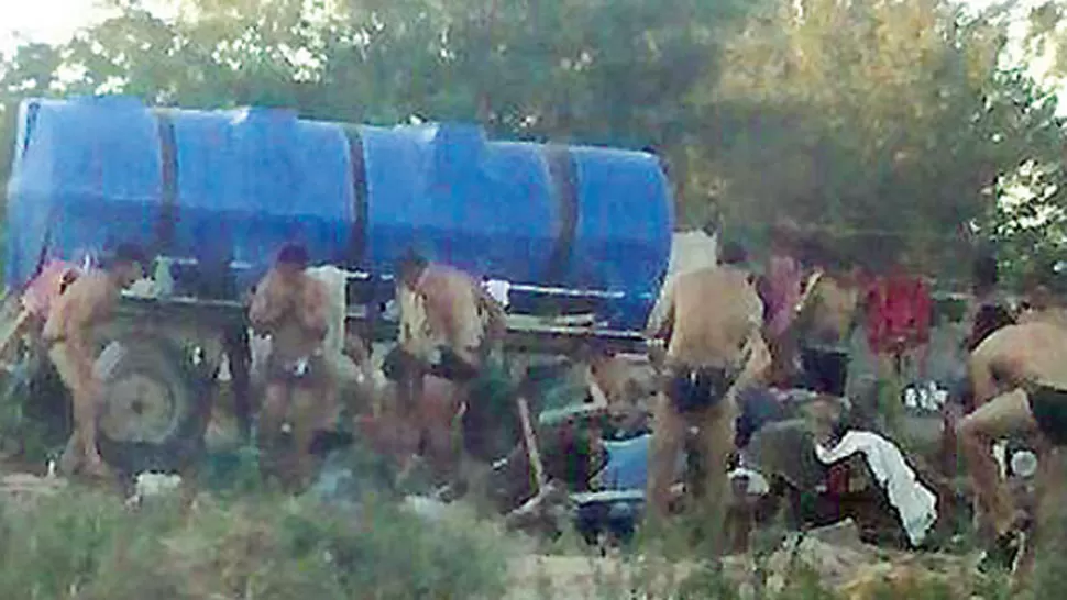 PÉSIMAS CONDICIONES. Los cosecheros tienen que asearse con tachos de agua, en medio del campo. FOTOS DE ELLIBERAL.COM.AR