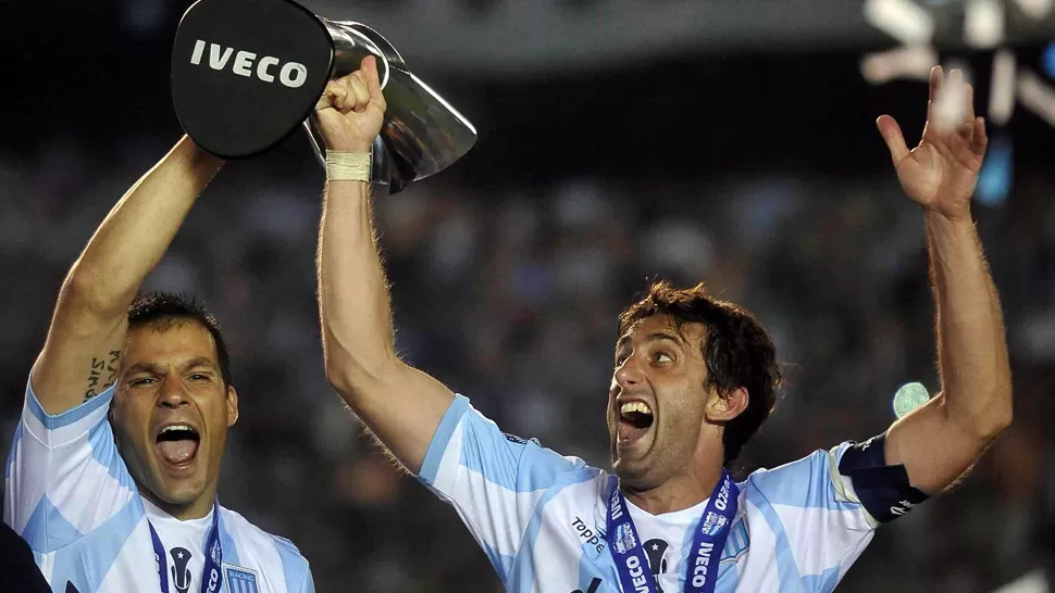 LA FIGURA. Milito, junto a Saja, levantan el trofeo del campeón. TELAM