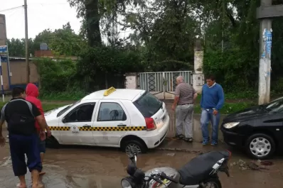 La calle estaba inundada, el chofer no vio el pozo y su auto se hundió