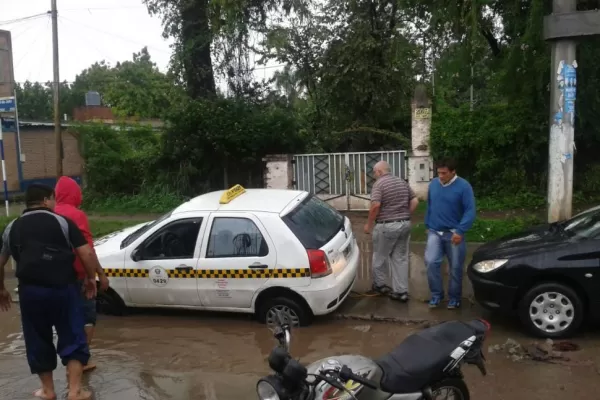 La calle estaba inundada, el chofer no vio el pozo y su auto se hundió