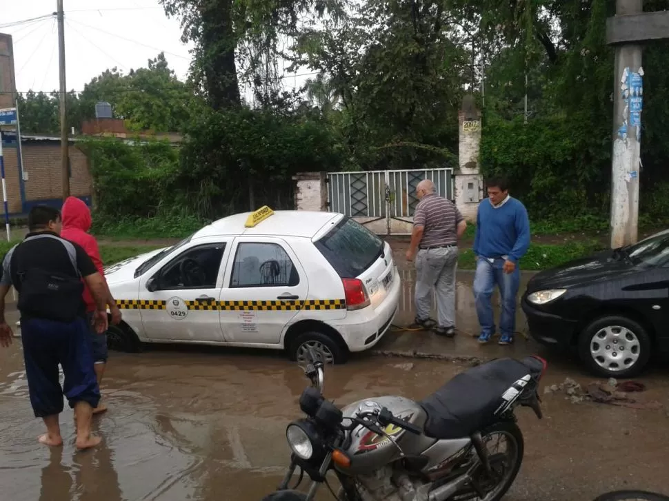 LA CALLE ESTABA INUNDADA, EL CHOFER NO VIO EL POZO Y SU AUTO SE HUNDIÓ
