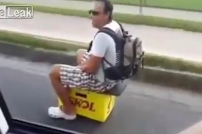 Un hombre conduce una moto hecha con un cajón de cerveza por la ruta