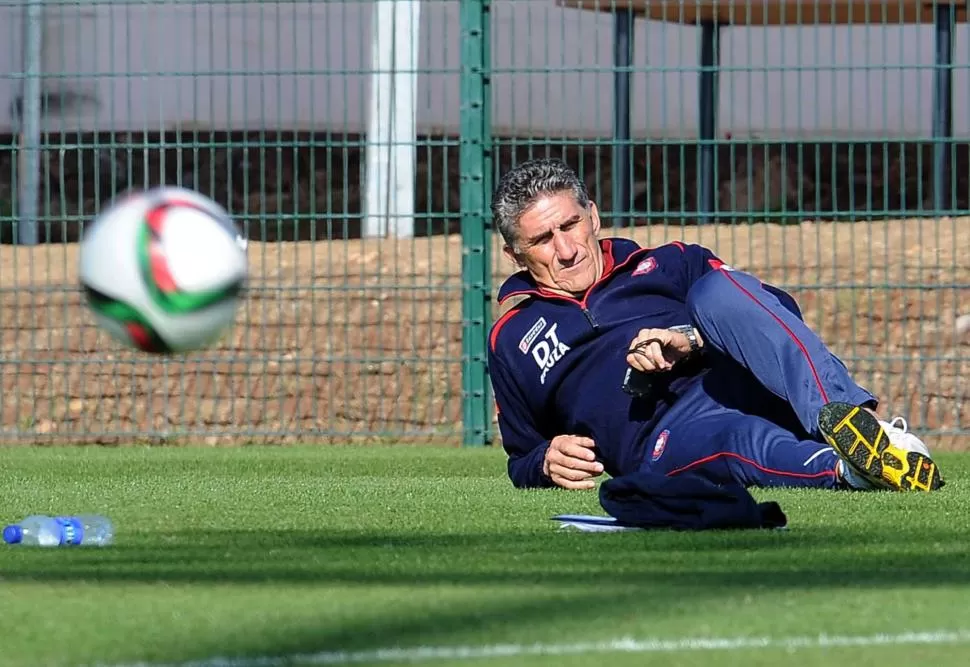 ¿RELAJADO? Bauza, acostado sobre la cancha de entrenamiento en Marruecos. télam