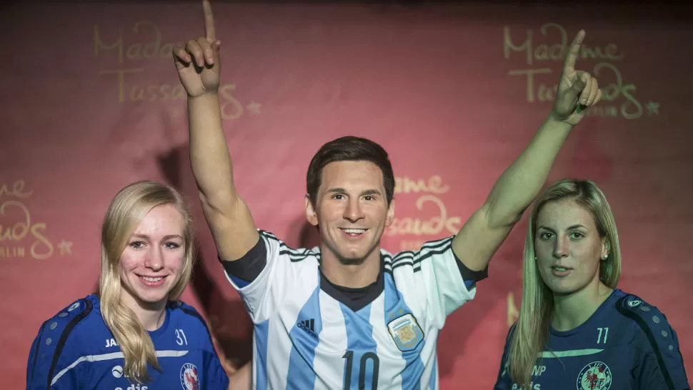 TODAS POSAN CON ÉL. Dos fanáticas no perdieron la chance de fotografiarse con el ídolo de cera. (FOTO REUTERS)